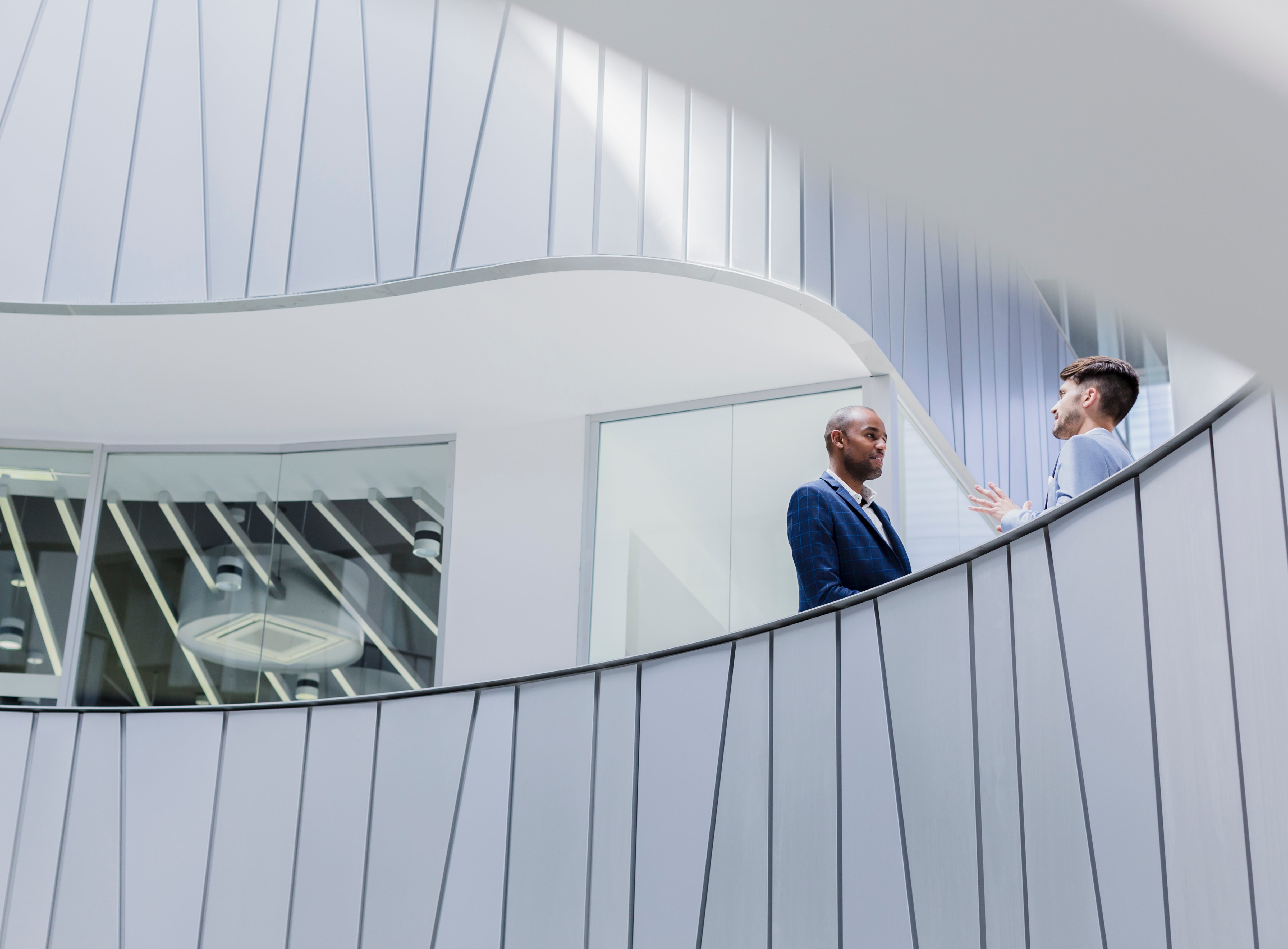 Businessmen talking on architectural, modern office balcony (1)